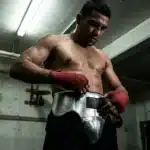 Athlète musclé enfile ses gants de boxe rouges