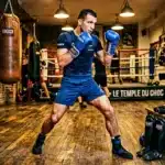 Boxeur en tenue bleue s'entraîne dans une salle de boxe