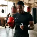 Boxeur en gants rouges s'entraînant dans une salle de sport