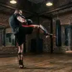 Boxeur exécute un coup de pied en salle d'entraînement