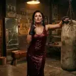 Femme en robe paillette rouge tenant sac de boxe