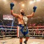 Boxeur victorieux lève les bras avec ceinture de champion
