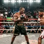 Deux boxeurs s'affrontent dans un ring sous les projecteurs