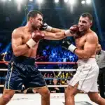 Deux boxeurs s'affrontant sur un ring professionnel avec public.