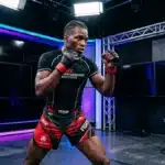 Athlète MMA en shorts rouges et noirs dans ring professionnel