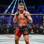 Combattant de MMA dans l'octogone UFC, gants rouges, public