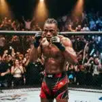 Athlète UFC en shorts rouges, poings levés, devant foule