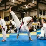 Deux judokas en kimono blanc exécutent des mouvements de Jiu-Jitsu